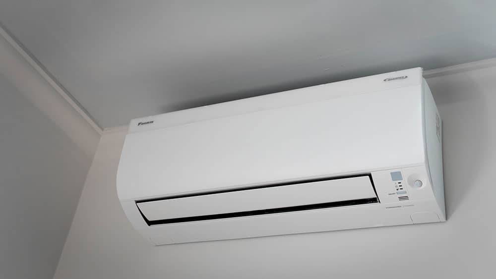 A white wallmount air conditioning system being installed in Manchester